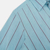 View 6 of product The Cendre Blue Track Stripe Westminster Shirt by Turnbull & Asser features a light blue hue, dark vertical stripes, button-down front, classic collar, and buttoned cuffs—showcasing British craftsmanship.