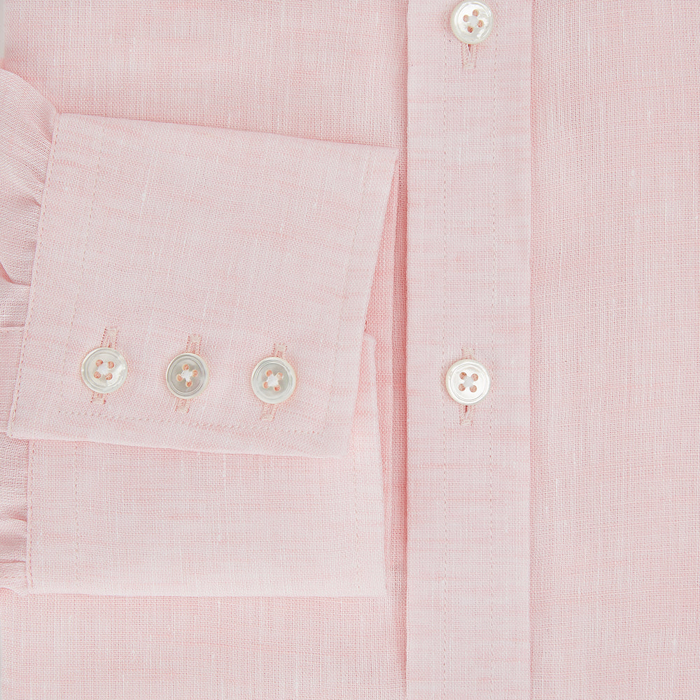 The Turnbull & Asser Pale Pink Linen Mayfair Shirt features a classic, formal style with long sleeves, a collar, and white buttons. Shown laid flat on a white background.