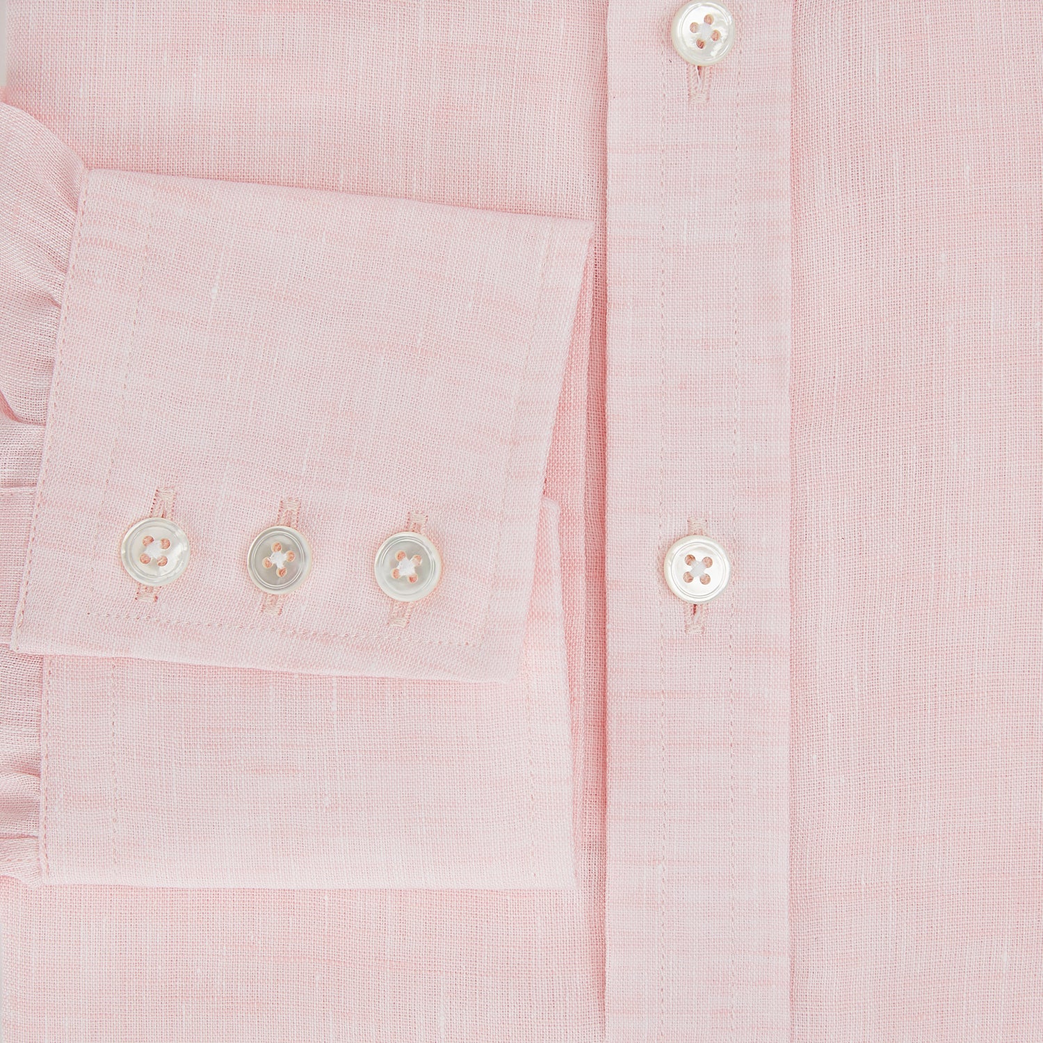 View 4 of product The Turnbull & Asser Pale Pink Linen Mayfair Shirt features a classic, formal style with long sleeves, a collar, and white buttons. Shown laid flat on a white background.