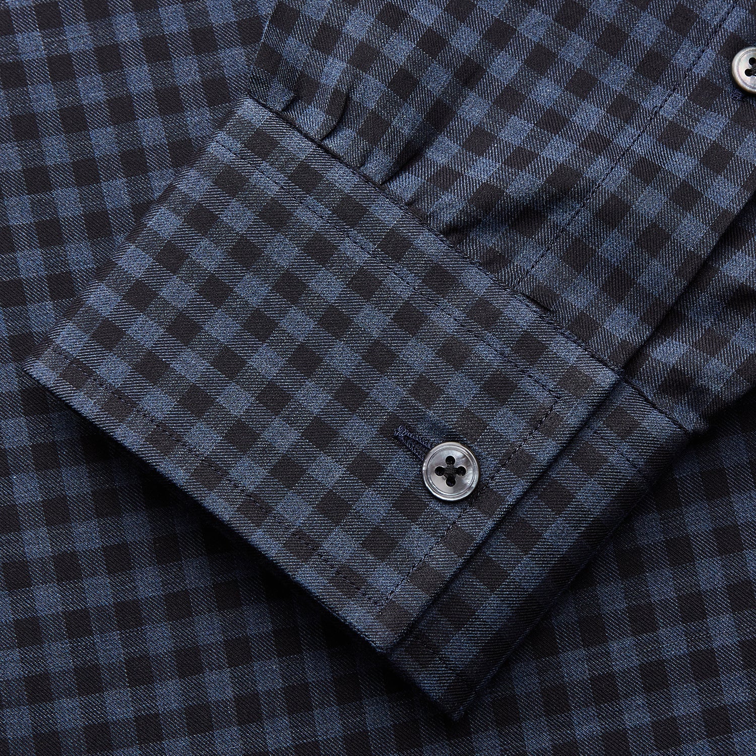 View 4 of product The Turnbull & Asser Navy Check Cotton Weekend Fit Blake Shirt features a long-sleeve, button-up design with a stand collar and white buttons, shown on a white background.