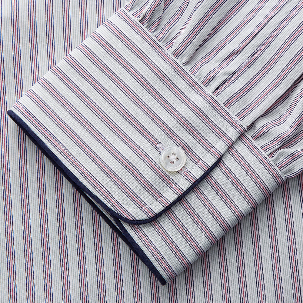 The Turnbull & Asser Red and Blue Multi Stripe Cotton Sussex Nightshirt features long sleeves, a knee-length cut, collared neckline, button placket, chest pocket with dark trim, and rounded hem for luxurious sleepwear.