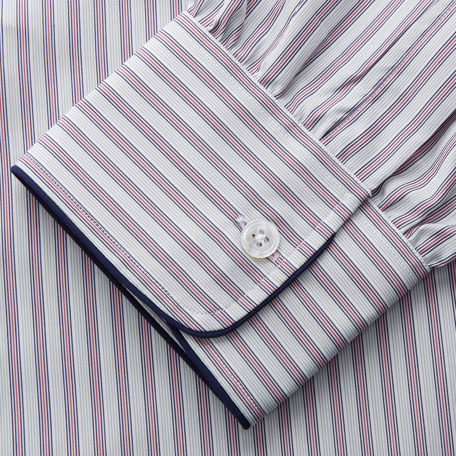 View 3 of product The Turnbull & Asser Red and Blue Multi Stripe Cotton Sussex Nightshirt features long sleeves, a knee-length cut, collared neckline, button placket, chest pocket with dark trim, and rounded hem for luxurious sleepwear.
