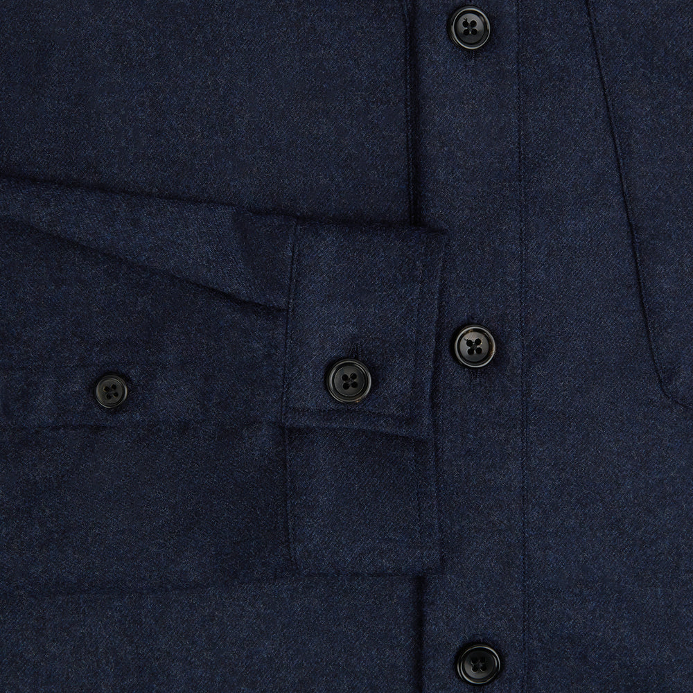 The Turnbull & Asser Mid Blue Highbury Overshirt features long sleeves, a button-up front, collar, and single chest pocket, shown laid flat on a white background.