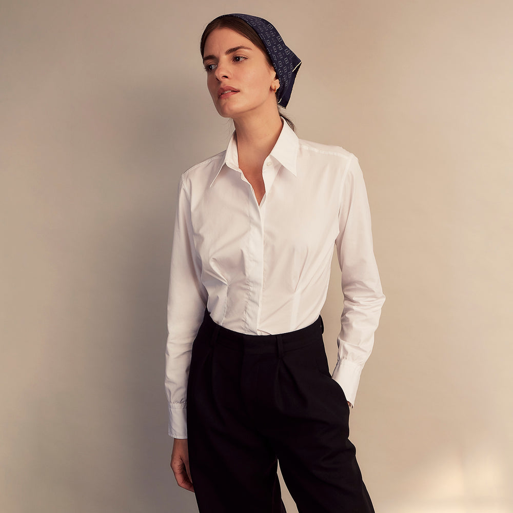 The White Cotton Tailored Bianca Shirt by Turnbull & Asser features a pointed collar and button cuffs, crafted from soft organic cotton and displayed flat on a white background for timeless elegance.