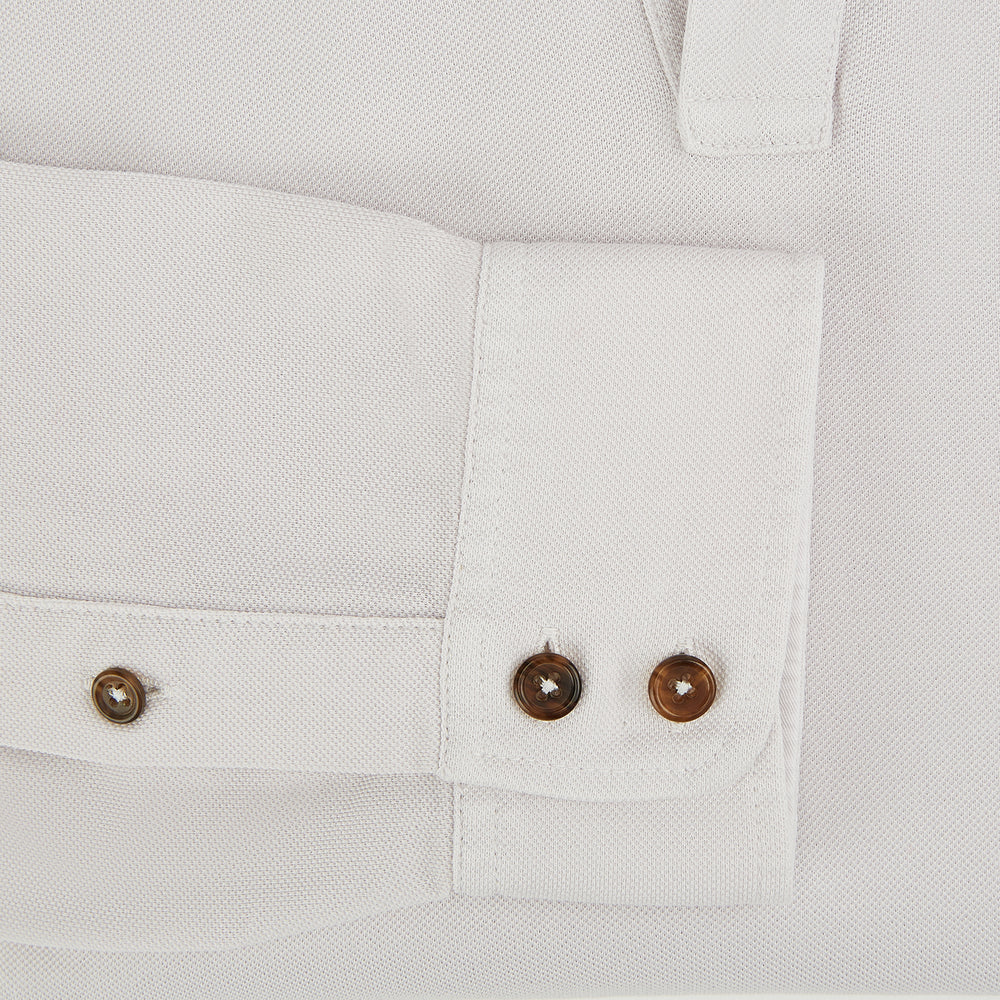 A pale pink luxury cotton rugby polo shirt by Turnbull & Asser, featuring long sleeves and a collar with no buttons, displayed flat on a white background.