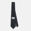 View 4 of product The Navy and White Square Silk Tie by Turnbull & Asser is crafted from English silk with a subtle white square pattern, rolled tip-forward and displayed on a white background for a tailored look.
