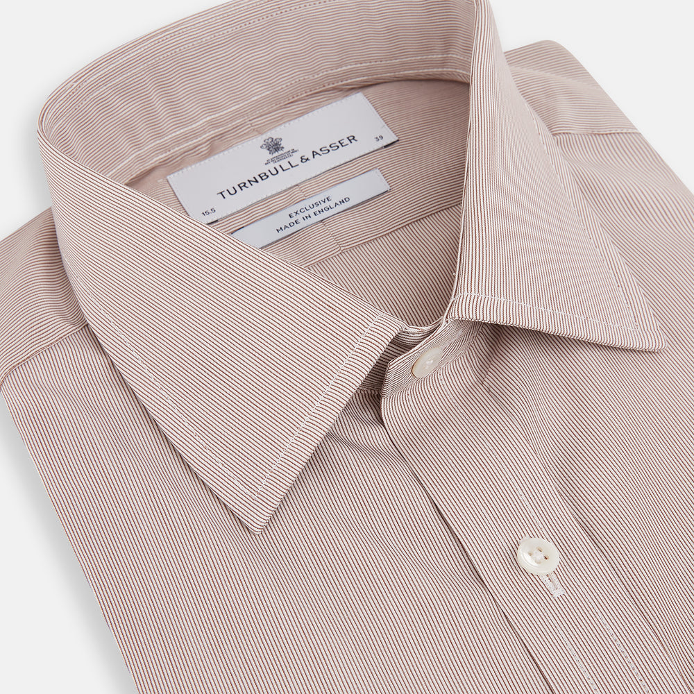 The Turnbull & Asser Burgundy Hairline Stripe Mayfair Shirt features long sleeves, a pointed collar, white buttons, and a classic Mayfair fit—perfect for formal occasions—presented against a plain white background.