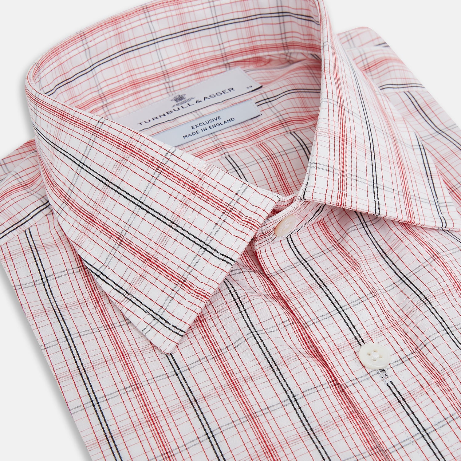 View 2 of product The Turnbull & Asser Red Multi Check Mayfair Shirt is a long-sleeve, button-up with a collar, crafted from Italian cotton and featuring a red multi check plaid pattern on white, shown laid flat against a white surface.