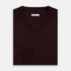 View 7 of product The Turnbull & Asser Burgundy Fine Merino V-Neck Jumper features a classic plain knit design with long sleeves, showcased against a crisp white background.
