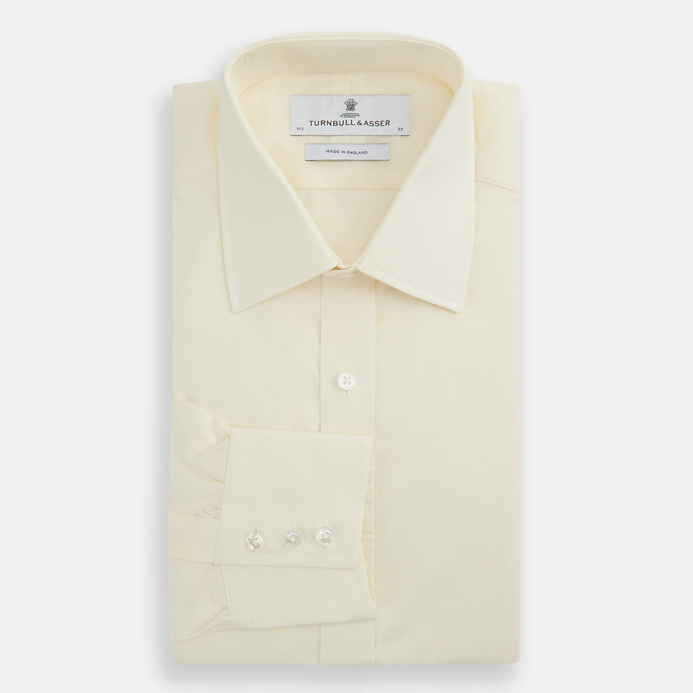 The Cream Cotton Shirt with T&A Collar and 3-Button Cuffs by Turnbull & Asser is ideal for minimalist styles or pairing with bold ties. Shown on a plain white background.