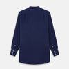 View 3 of product The Turnbull & Asser Blue Soft-touch Silk Lauren Shirt is a navy, long-sleeve button-up with an Igret stand collar, white buttons, curved hem, relaxed fit, and elongated body for a modern look, shown laid flat on a white background.
