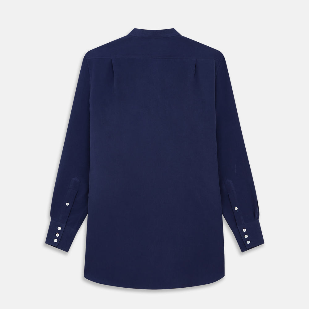 The Turnbull & Asser Blue Soft-touch Silk Lauren Shirt is a navy, long-sleeve button-up with an Igret stand collar, white buttons, curved hem, relaxed fit, and elongated body for a modern look, shown laid flat on a white background.