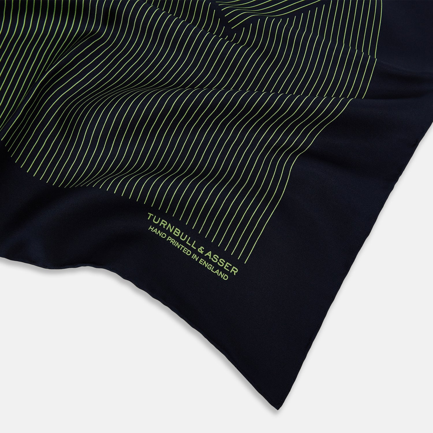 View 2 of product The Navy and Melon Green Stripe Silk Pocket Square by Turnbull & Asser features refined stripes, hand-printed branding in the corner, and is finished with elegant hand-rolled edges.