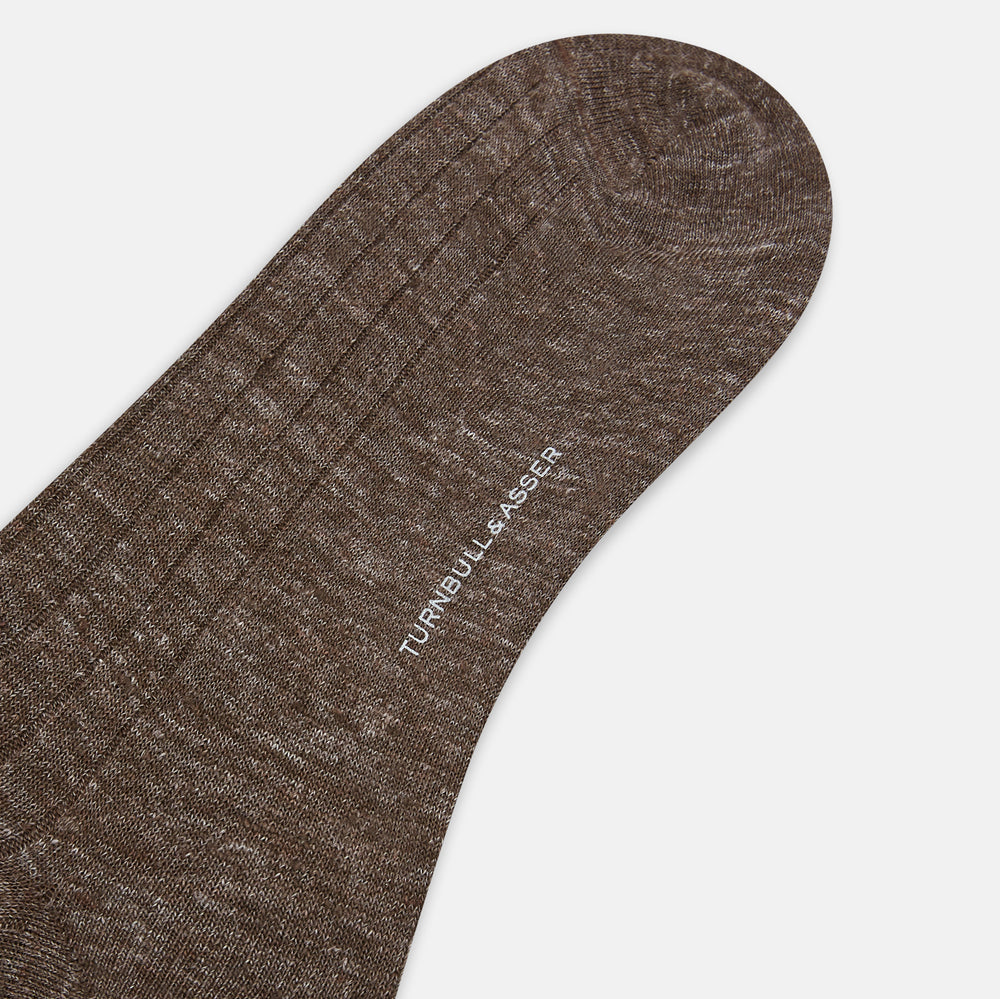 A single Dark Chocolate Linen Mid-Length Sock by Turnbull & Asser, ribbed and breathable, stands upright with its foot slightly raised against a plain white background.