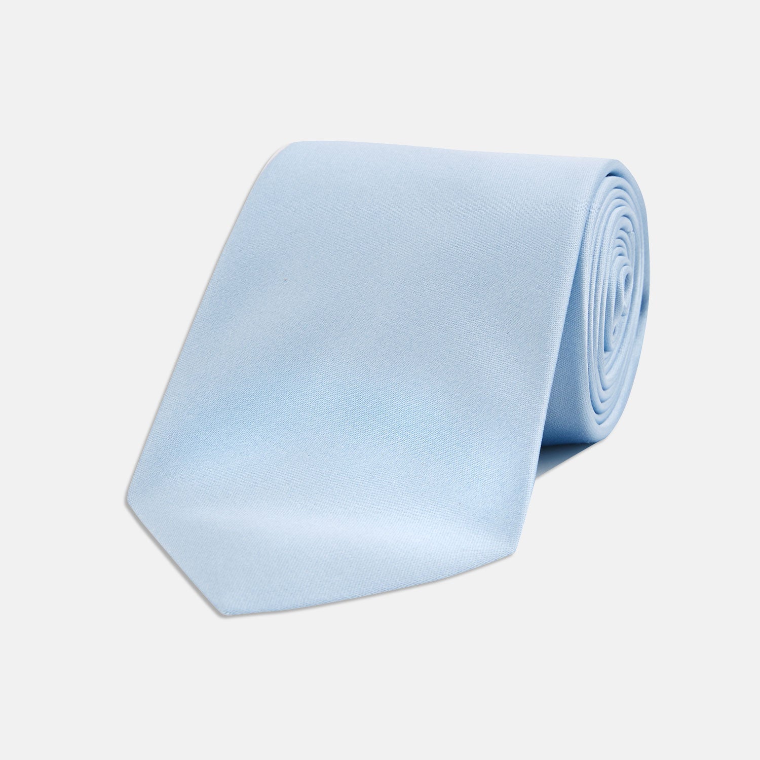 View 1 of product The Turnbull & Asser Plain Woven Satin Silk Tie, in light blue, is neatly rolled and displayed on a plain white background—an essential accessory for refined style.