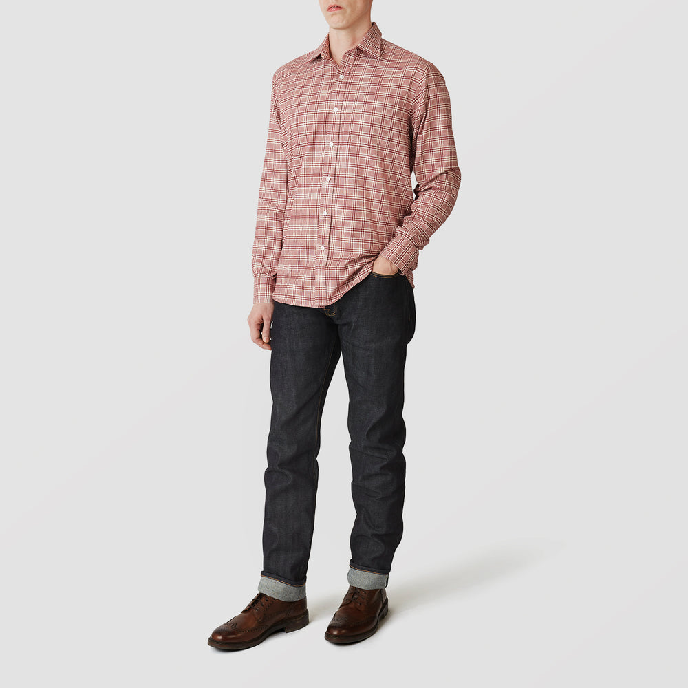 A person in a Turnbull & Asser Red Check Weekend Fit Shirt with a Derby collar and 1-button cuffs, paired with dark cuffed jeans and brown shoes, stands against a plain light background for an ideal winter layered style.