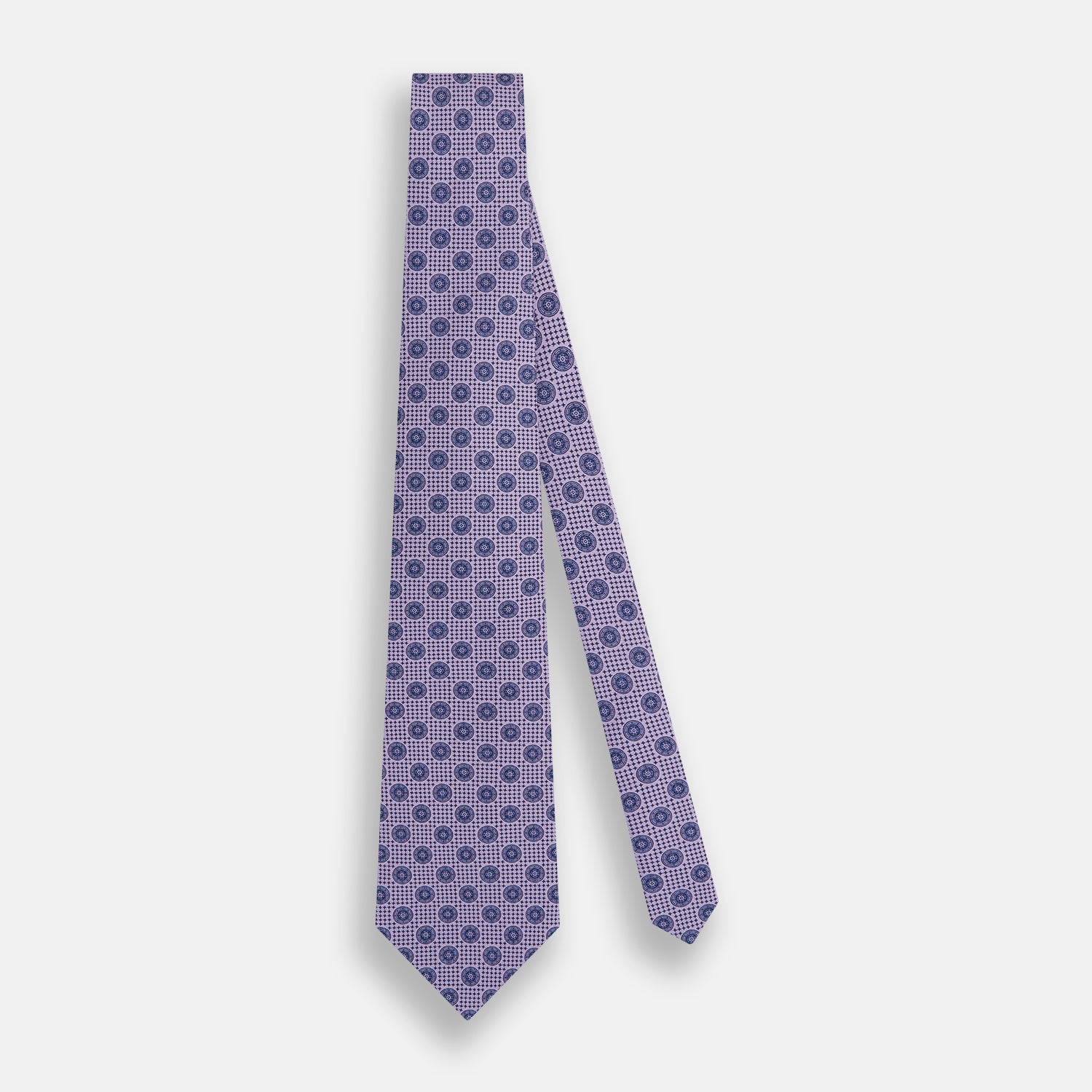 View 2 of product The Turnbull & Asser Lilac Medallion Silk Tie features a repeating navy medallion motif on textured lilac silk, adding refined style to any ensemble.