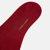 View 3 of product Turnbull & Asser's Wine Long Socks: a single, over-the-calf sock in solid deep red with ribbed texture, displayed on a plain light background.