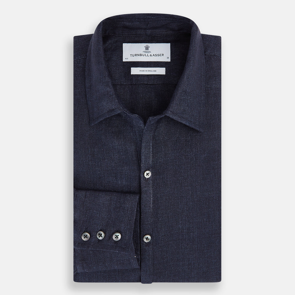 The Navy Linen Windsor Shirt by Turnbull & Asser features long sleeves, white buttons, a Turnbull collar, and buttoned cuffs in dark navy blue linen. Shown laid flat on a white background.