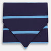 View 1 of product The Turnbull & Asser Azzurro Stripe and Navy Silk Cravat is elegantly displayed against a white background, featuring two horizontal light blue stripes and a bottom edge forming a downward-pointing triangle.