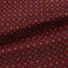 View 4 of product The Great Gatsby Burgundy Printed Silk Cravat by Turnbull & Asser features a maroon silk fabric with a small yellow and blue geometric pattern, subtle sheen, and neatly finished edges for an elegant, Gatsby-inspired formal accessory.