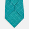 View 3 of product The Turnbull & Asser Turquoise Dotted Check Pattern Printed Silk Tie is shown rolled up on a plain white background.