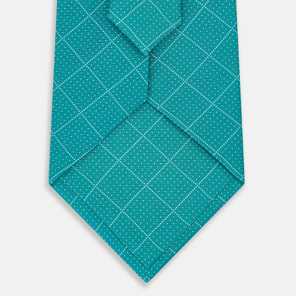The Turnbull & Asser Turquoise Dotted Check Pattern Printed Silk Tie is shown rolled up on a plain white background.
