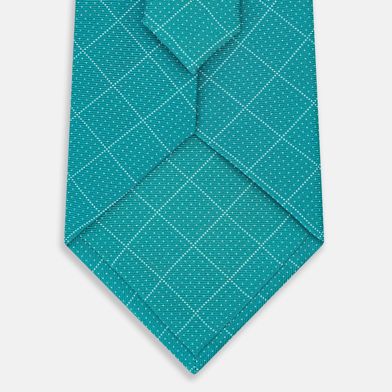View 3 of product The Turnbull & Asser Turquoise Dotted Check Pattern Printed Silk Tie is shown rolled up on a plain white background.