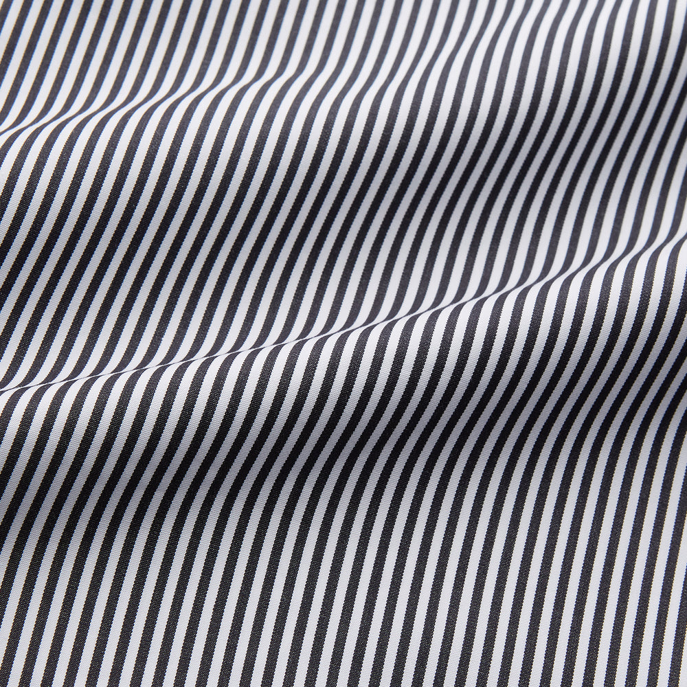 The Turnbull & Asser Black Candy Stripe Cotton Hyde Pyjama Set for men features soft cotton striped pajamas with a long-sleeve, button-up shirt detailed with black piping and three pockets, plus matching pants, both laid flat on a white background.