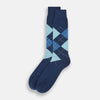 View 2 of product The Azzurro Wool Check Mid-Length Socks by Turnbull & Asser are navy blue with a ribbed cuff, featuring an argyle pattern in light blue, teal, and navy with white accents. Displayed upright against a plain white background.