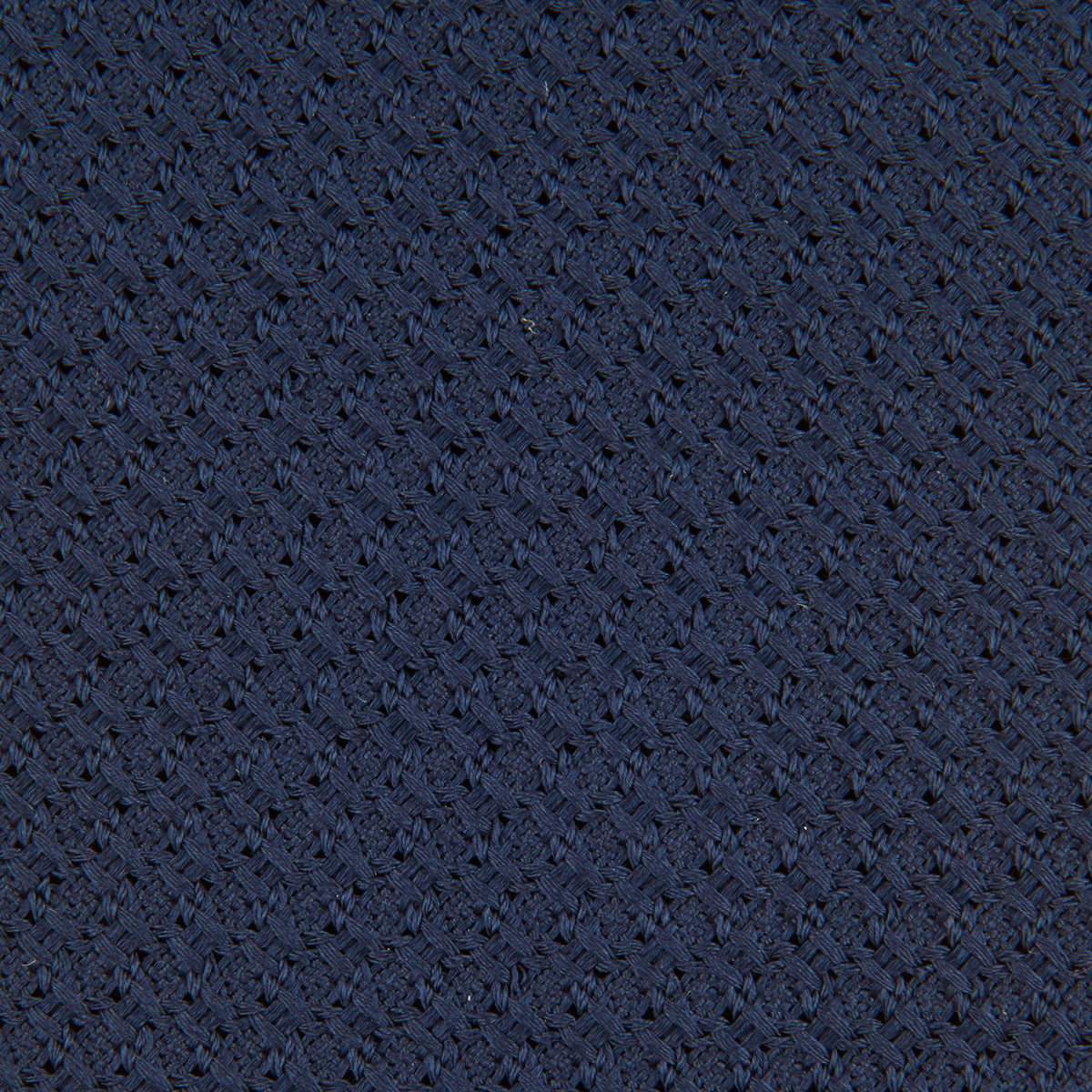 View 3 of product The Turnbull & Asser Navy Plain Woven Grenadine Silk Tie, an essential accessory, is rolled at one end and displayed on a plain white background.