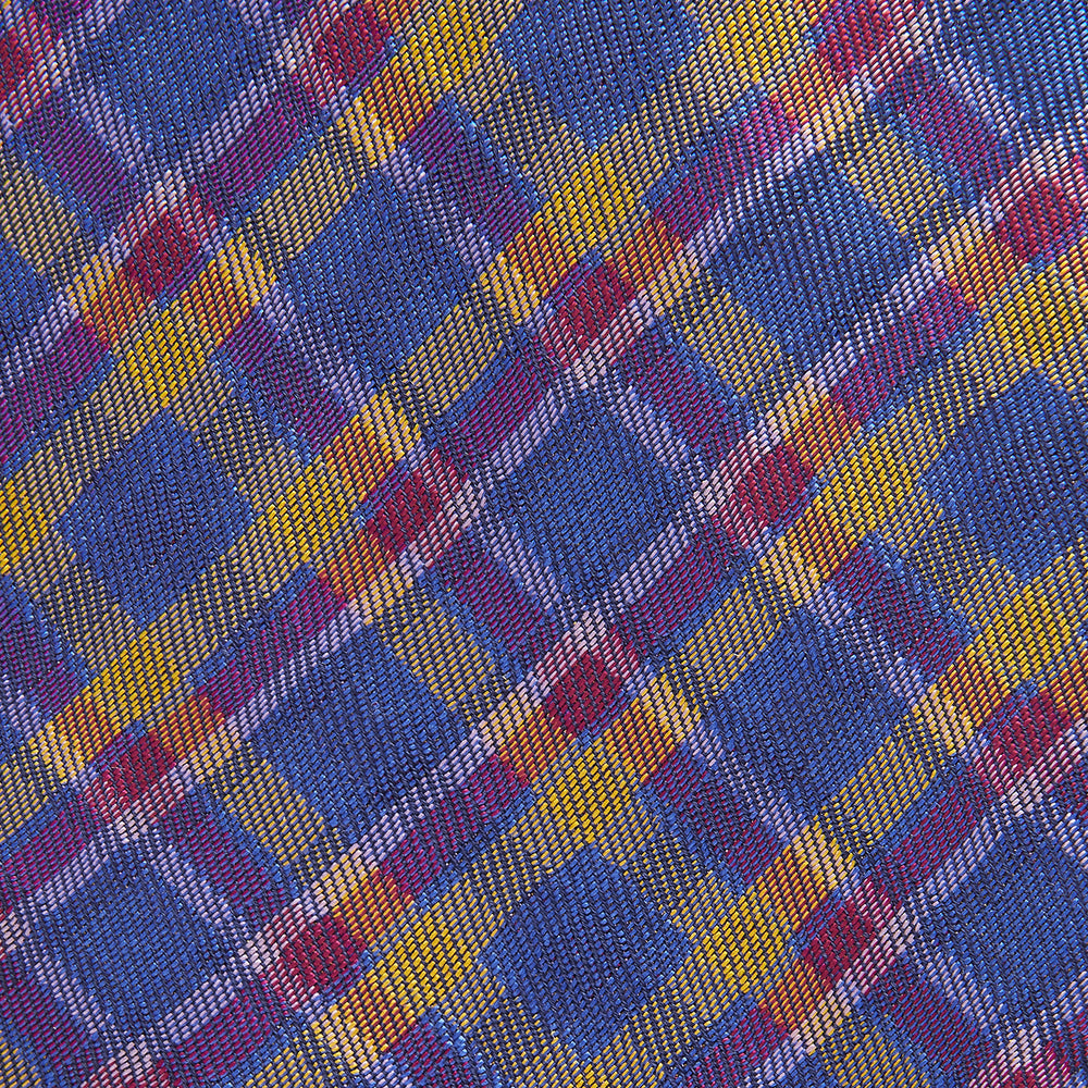 The Turnbull & Asser Blue Multi Tartan Silk Tie features a vibrant blue, yellow, and pink plaid pattern and is shown rolled up on a white background.