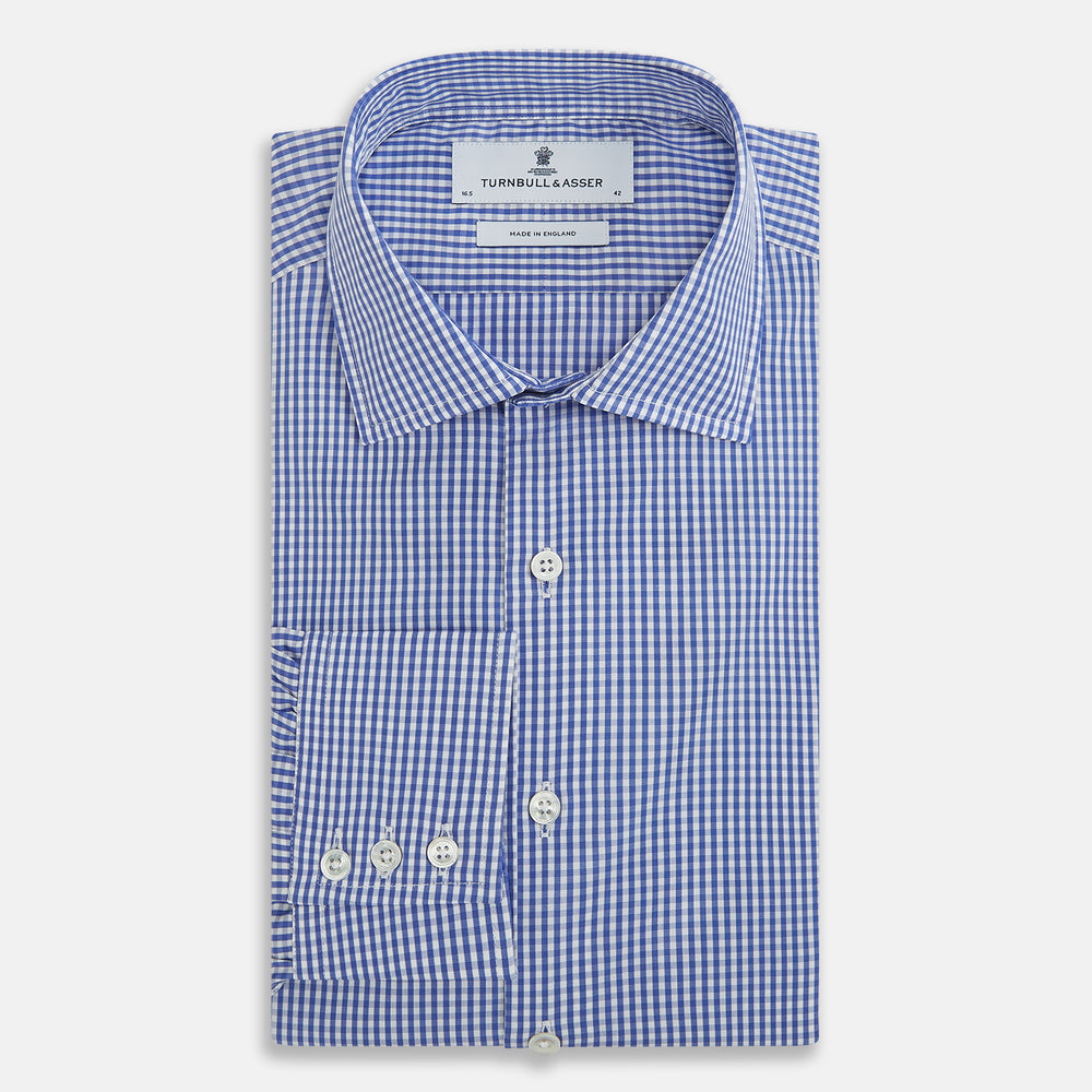 The Turnbull & Asser Blue Grid Check Belgravia Shirt, made from pure cotton with long sleeves, a spread collar, buttoned cuffs, and a blue-and-white check pattern, is laid flat on a white background.