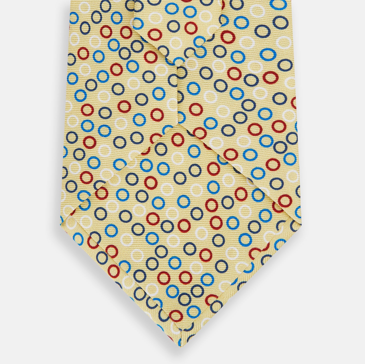 View 3 of product The Turnbull & Asser Multi-coloured Circle Yellow Silk Tie, crafted from fine English silk, features a vibrant pattern of multicoloured circles and is elegantly displayed rolled on a white background.