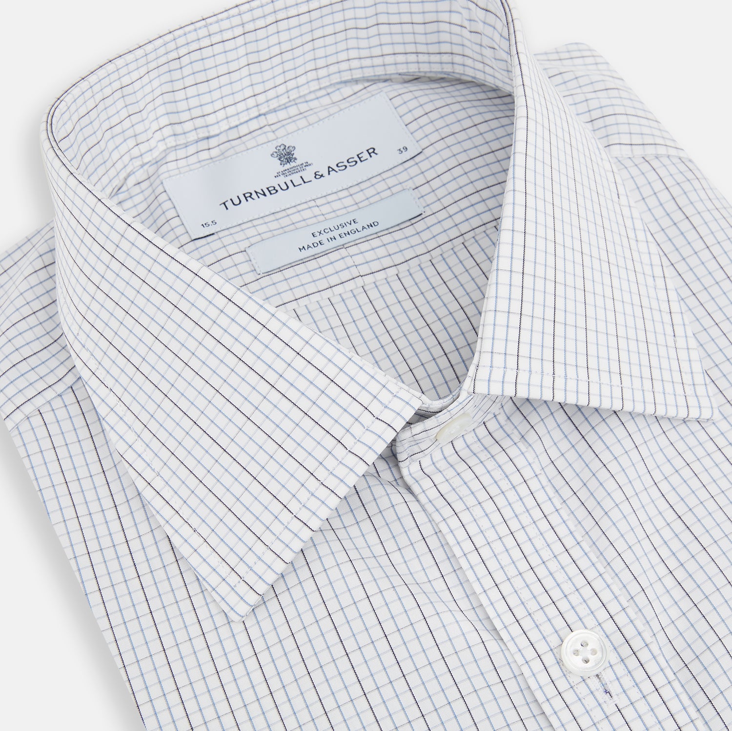 View 2 of product The Turnbull & Asser Pale Blue and Grey Grid Check Mayfair Shirt features long sleeves, a pointed collar, and buttoned cuffs. Crafted from Italian cotton, it displays a subtle grid pattern on a plain white background.