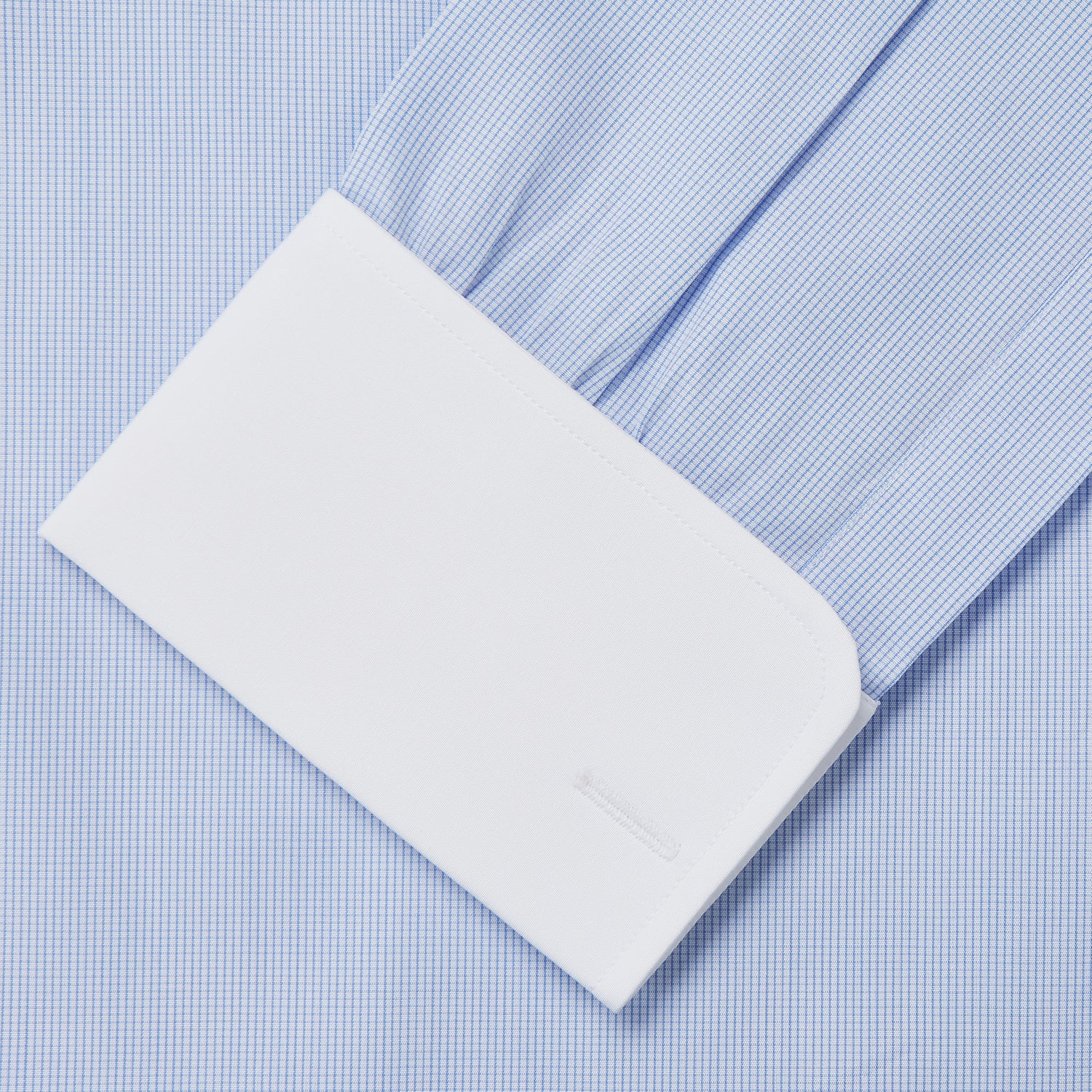 View 3 of product The Turnbull & Asser Micro Blue Check with White Collar and Cuff Shirt, a light blue long-sleeve style, features contrasting white collar and cuffs, buttoned down the front and laid flat on a white background.