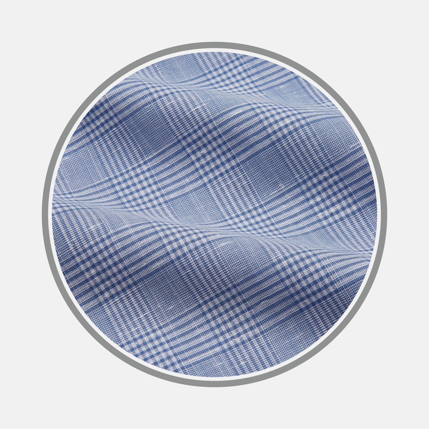 View 1 of product Close-up of Turnbull & Asser’s Pale Blue Multi Check Cotton Fabric featuring a light blue and white crisscross plaid pattern, displayed inside a circular frame with a gray border. The cloth shows slight wrinkling.