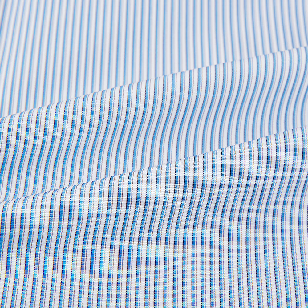 The Turnbull & Asser Pale Blue Pinstripe Mayfair Shirt features pale blue pinstripes, a classic T&A collar, white buttons, and cuffed sleeves, shown against a plain white background.