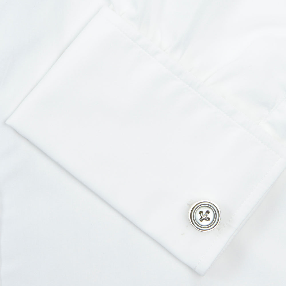 A Turnbull & Asser Two-Fold 200 White Cotton Shirt with T&A collar and double cuffs, neatly folded to show the label inside the collar, is displayed on a light blue background.
