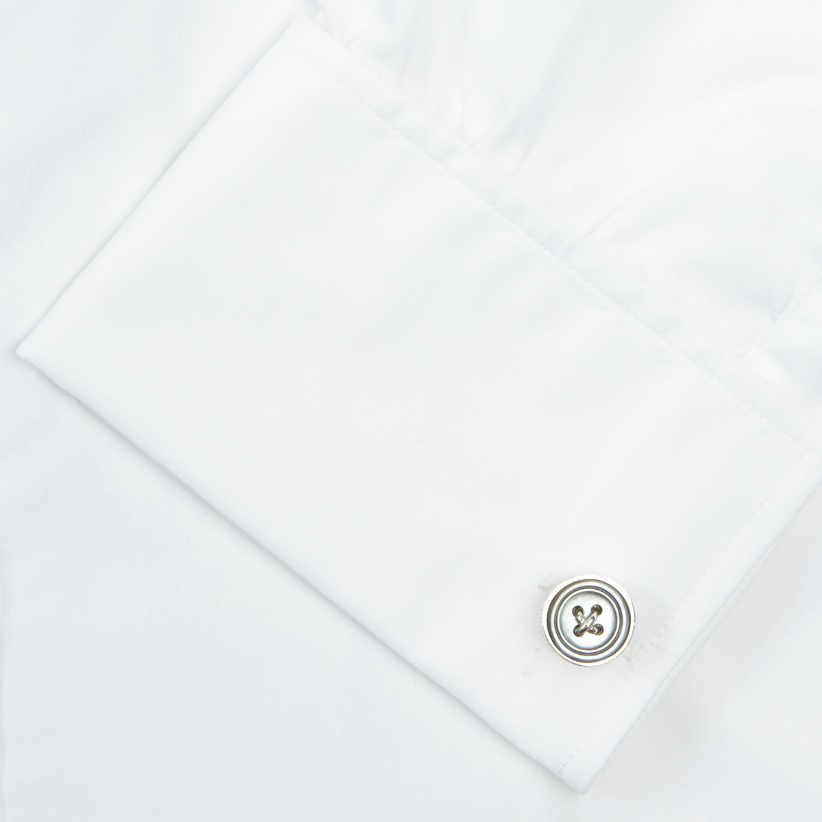 View 6 of product A Turnbull & Asser Two-Fold 200 White Cotton Shirt with T&A collar and double cuffs, neatly folded to show the label inside the collar, is displayed on a light blue background.