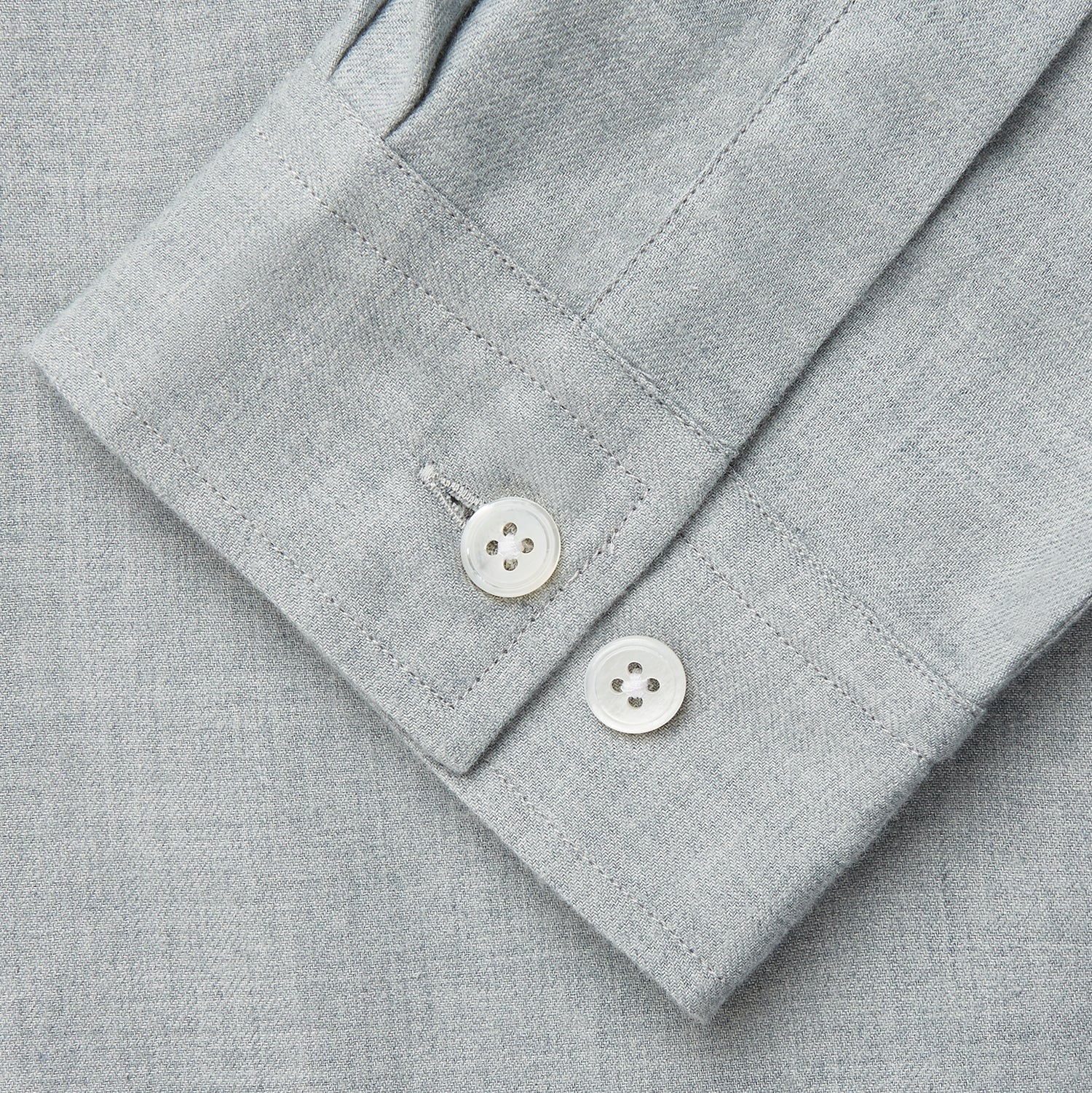 View 4 of product A man stands against a beige background wearing the Turnbull & Asser Cloud Blue Cashmerello Holiday Fit Fellows Shirt, styled with dark trousers, a black belt, and black shoes, looking directly at the camera with a neutral expression.