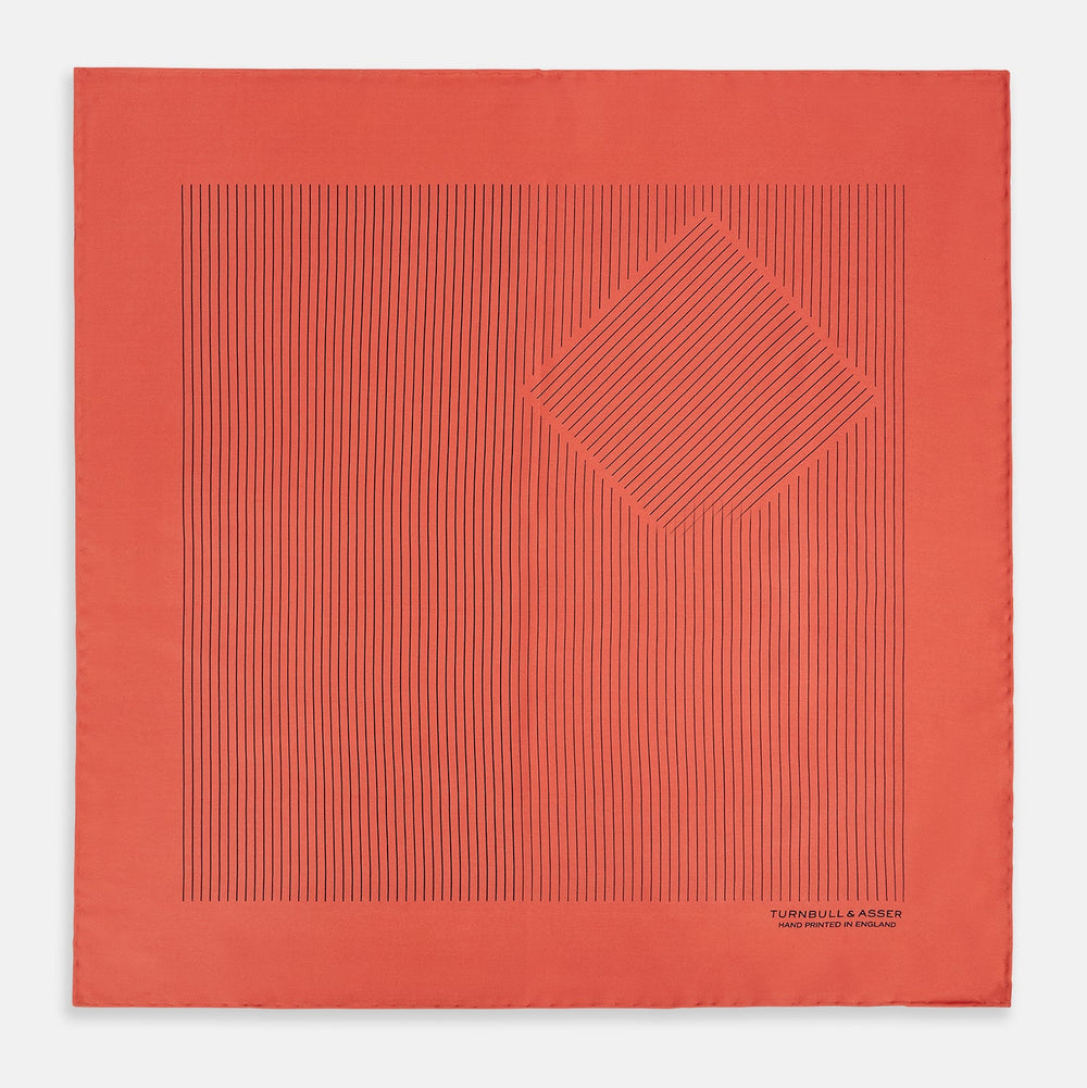 The Orange Stripe Silk Pocket Square by Turnbull & Asser features thin black vertical lines and "TURNBULL & ASSER HAND PRINTED IN ENGLAND" in the corner, neatly folded on a white background.