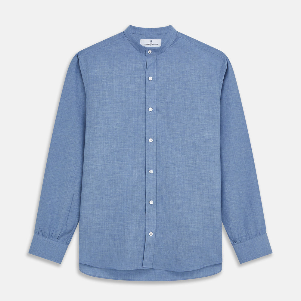 The Turnbull & Asser Blue Cotton Weekend Fit Blake Shirt features a light blue color, long sleeves, stand collar, white buttons, and a curved hem—ideal for casual weekends. Laid flat on a white background.