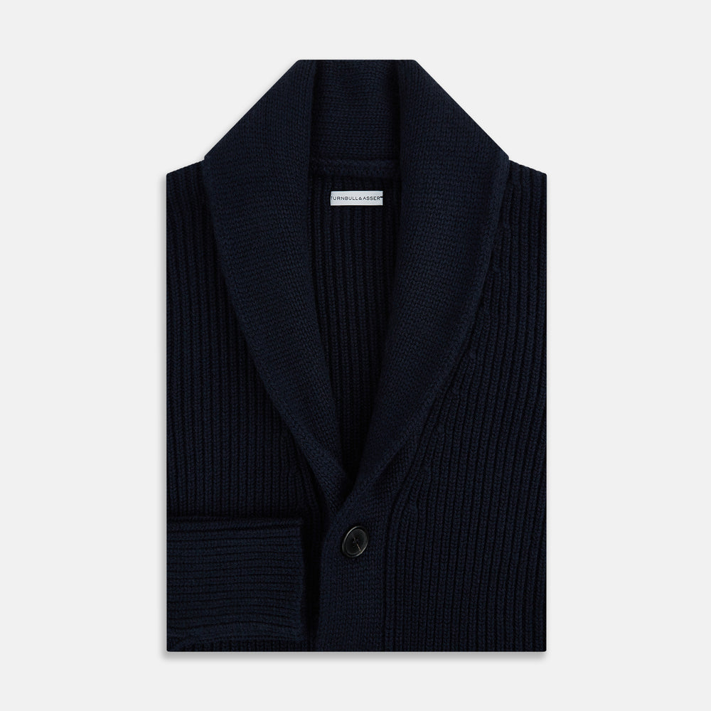 The Turnbull & Asser Midnight Blue Cashmere Shawl Collar Cardigan features ribbed fabric, five black front buttons, a shawl collar, and two front patch pockets, shown against a plain light background.