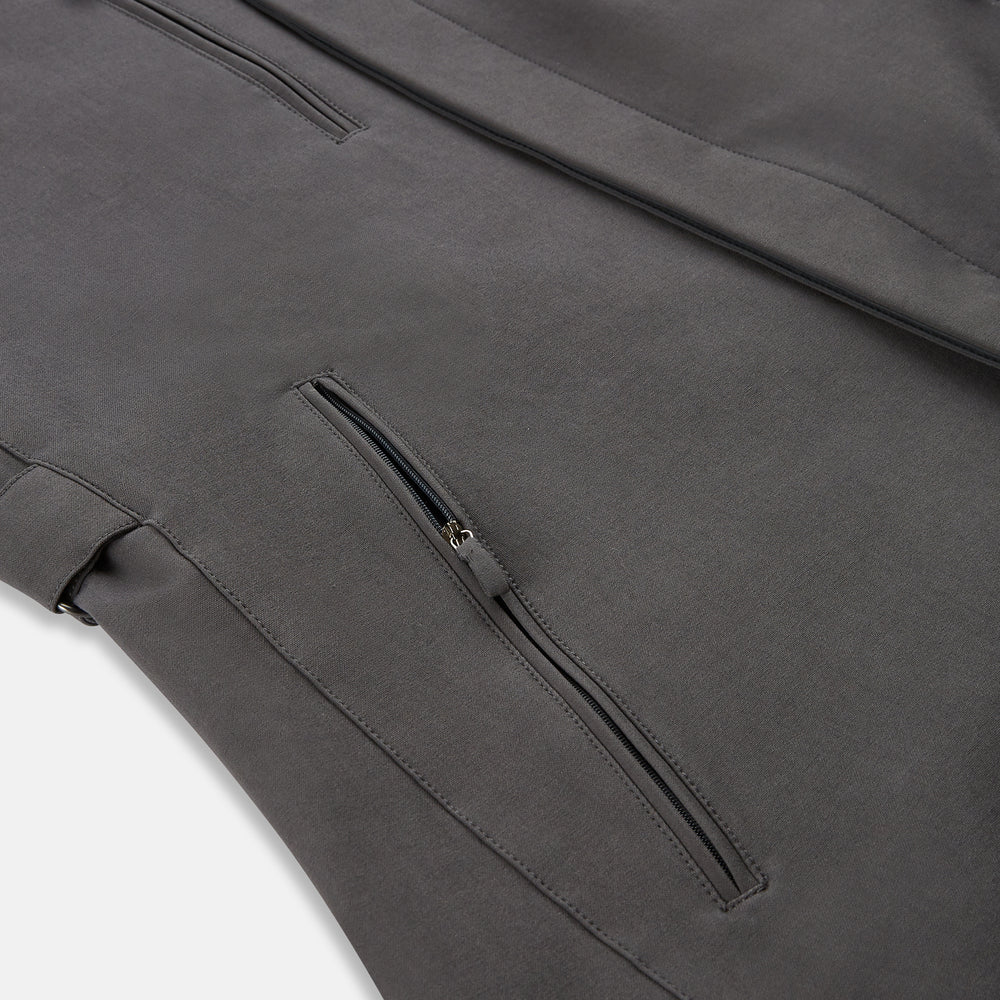 The Turnbull & Asser Charcoal Melange John Arthur Trench Coat, featuring a collar, single-breasted closure, and three zippered pockets—one chest and two at the hips—is shown against a plain white background.