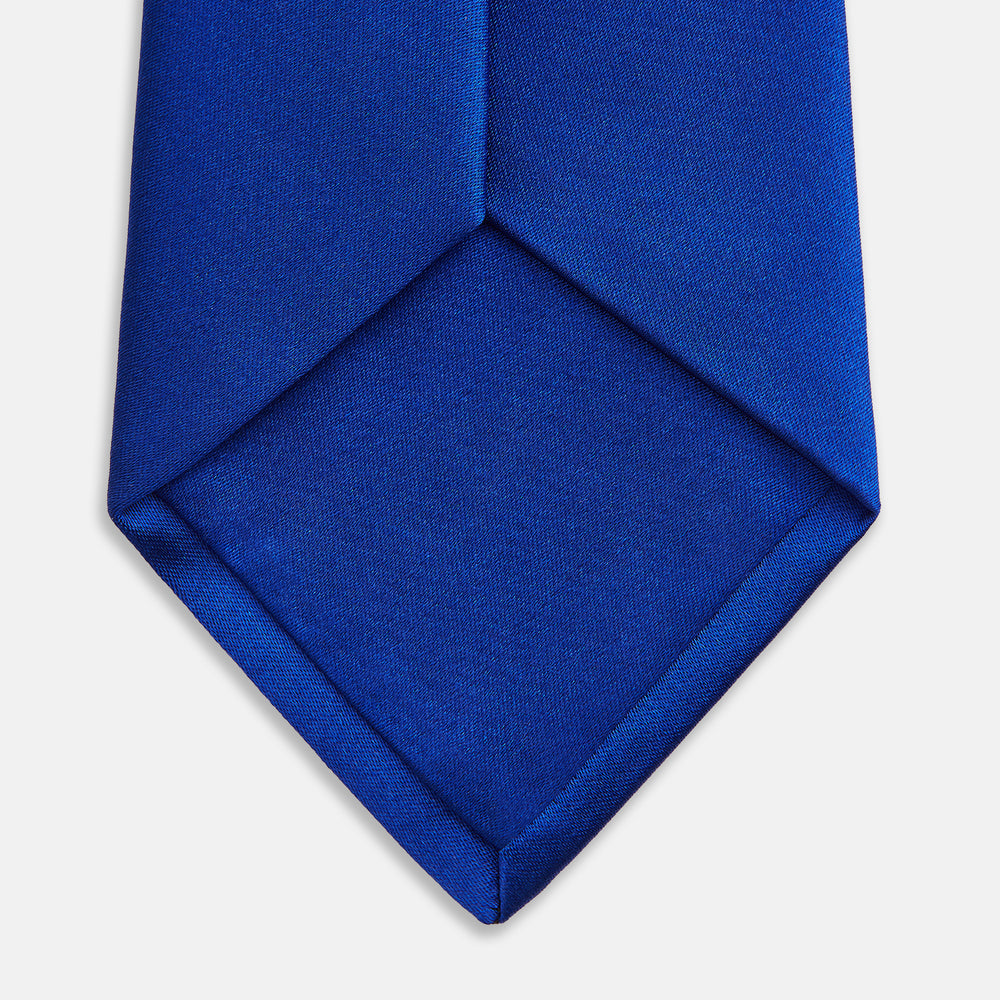 The Turnbull & Asser SATIN CRUISE TIE, in vibrant royal blue with a smooth, lustrous finish, creates a striking contrast against a plain white background.