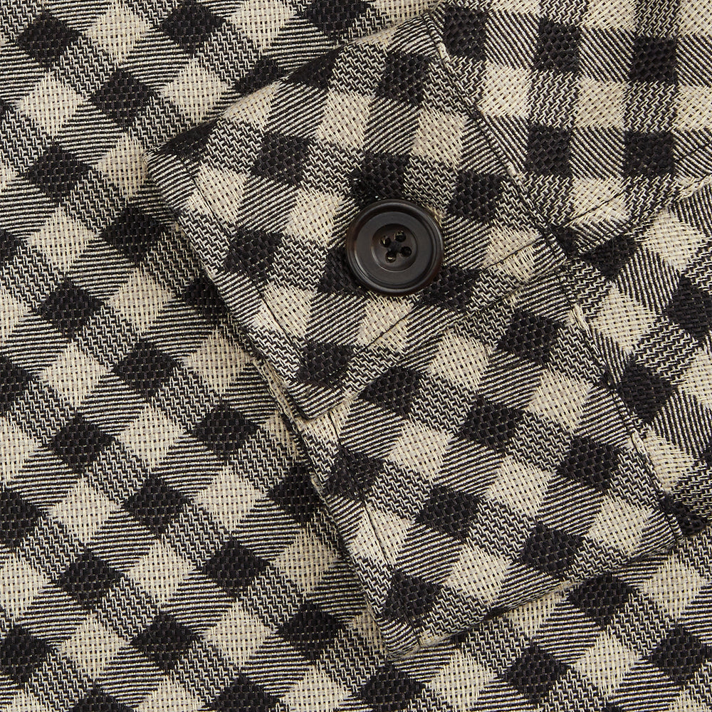 The Turnbull & Asser Black Gingham Check Wool Blend Somerset Overshirt features long sleeves, two chest flap pockets with buttons, and a black-and-beige check pattern. Shown laid flat on a white background; ideal as transitional outerwear.