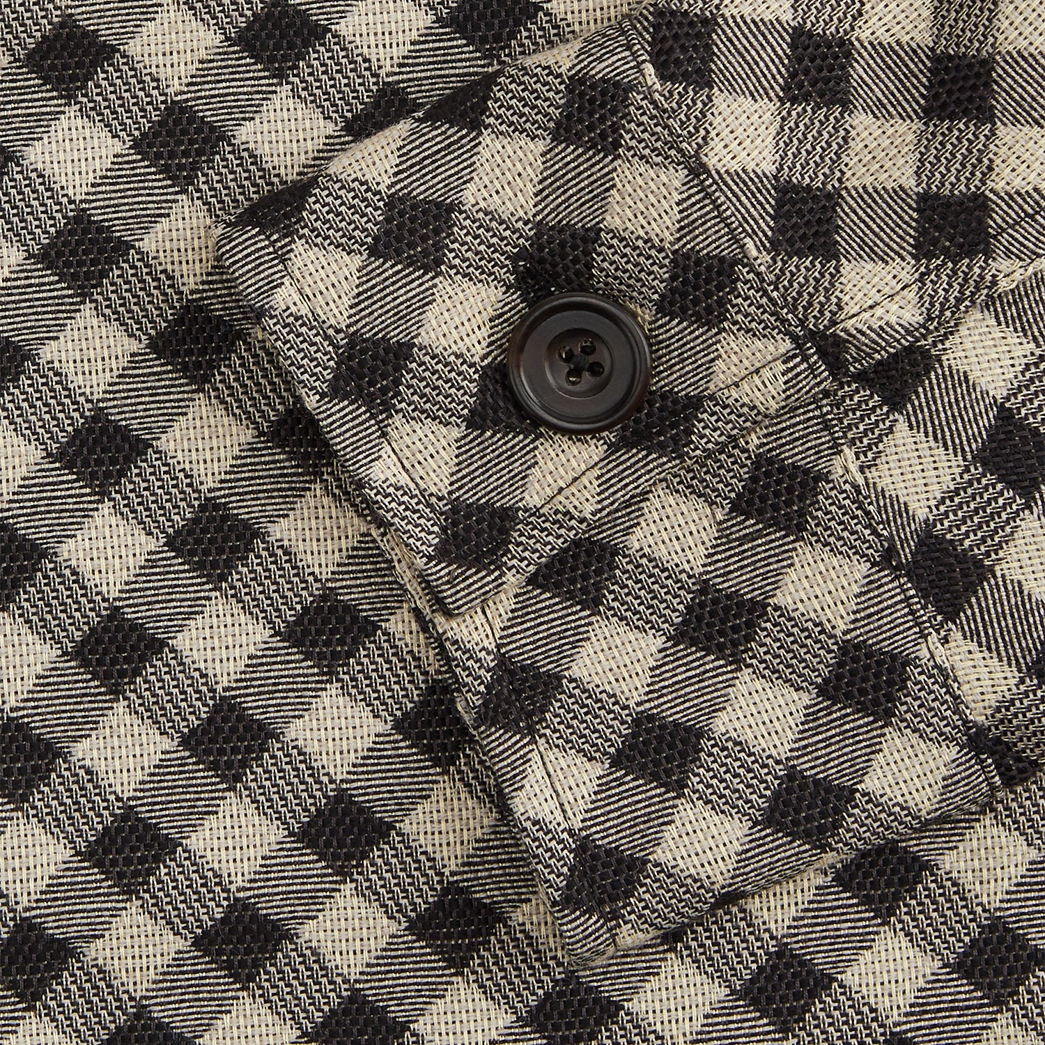 View 3 of product The Turnbull & Asser Black Gingham Check Wool Blend Somerset Overshirt features long sleeves, two chest flap pockets with buttons, and a black-and-beige check pattern. Shown laid flat on a white background; ideal as transitional outerwear.