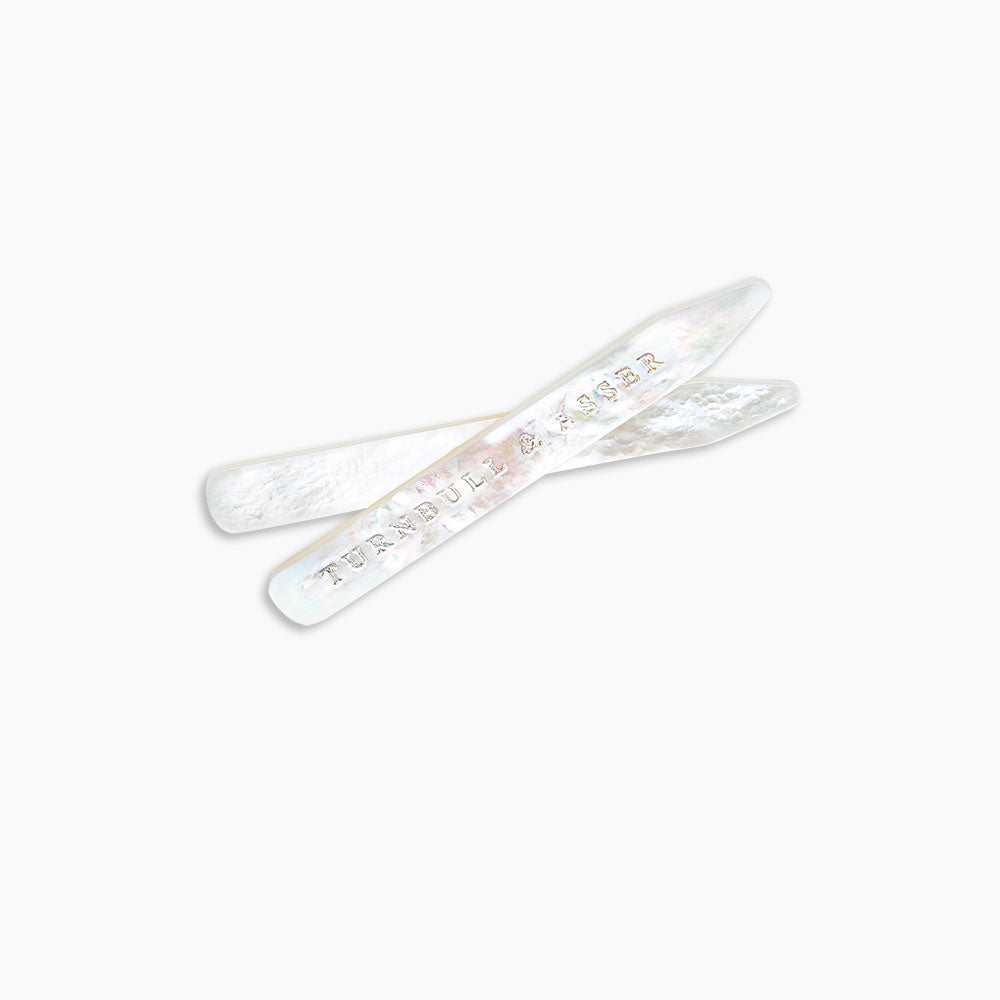 Two Turnbull & Asser Mother-of-Pearl Collar Stays, one engraved with the brand name, are displayed side by side on a plain light background.