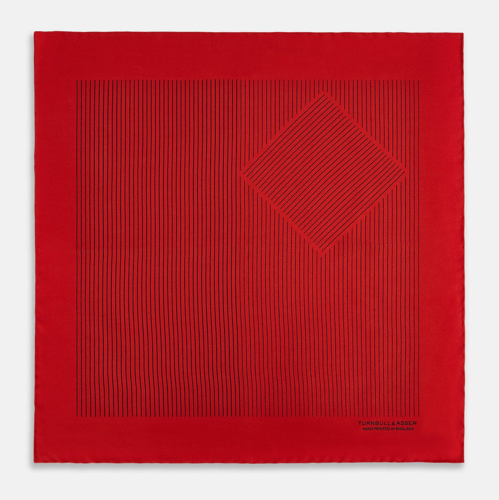 The Red Stripe Silk Pocket Square by Turnbull & Asser features thin black vertical lines and the brand signature in black on one corner, with a neatly folded edge for a touch of classic British style.